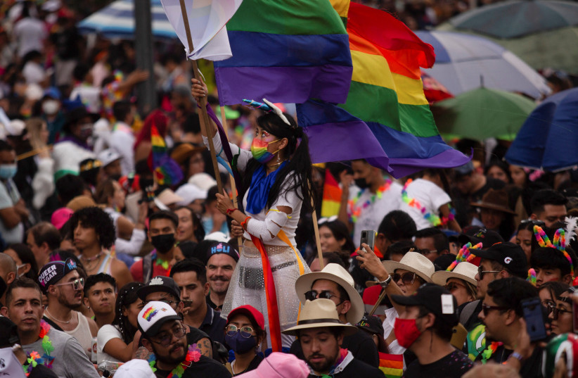 A woman holds a flag as she attends the LGBTQ+ Pride Parade after being cancelled for two years due to the coronavirus disease (COVID-19) pandemic in Mexico City, Mexico June 25, 2022. (credit: Quetzalli Nicte-Ha/REUTERS)