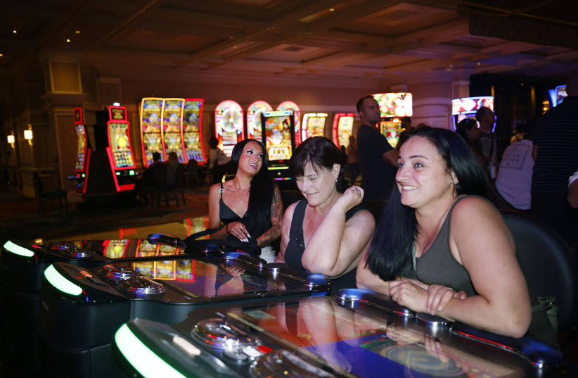  Stacey McLachlan, right, of Vancouver, plays an electronic table game at the Bellagio on Oct. 6, 2022, in Las Vegas, with her mother Sharon, middle, and their friend Ciara Tabb, left. (photo credit: CHITOSE SUZUKI/LAS VEGAS REVIEW-JOURNAL/TNS)