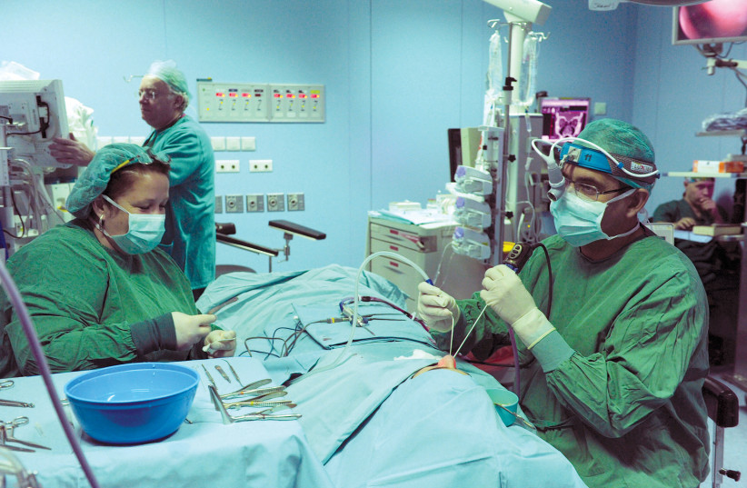  Surgeons perform surgery on a patient at Assuta Medical Center in Tel Aviv.  (credit: Moshe Milner/GPO)