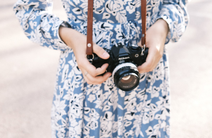  Woman holding camera (illustrative) (photo credit: PEXELS)