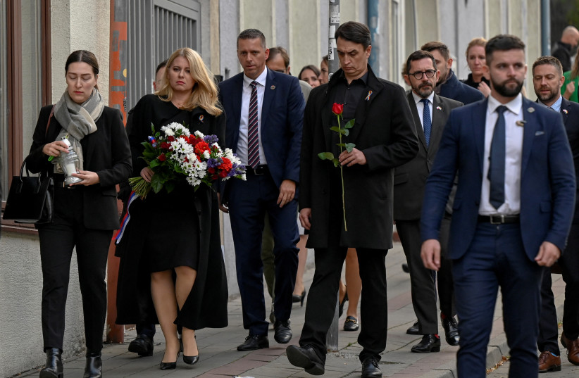  Slovakia's President Zuzana Caputova carries flowers as she waks next to her partner Juraj Rizman near the site of a shooting in Bratislava, Slovakia October 13, 2022. (credit: REUTERS/RADOVAN STOKLASA)