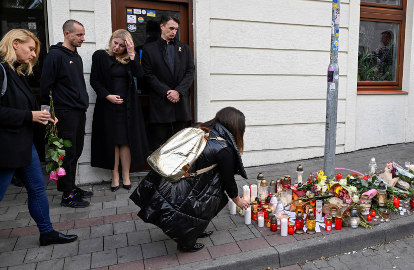  Slovakia's President Zuzana Caputova stands next to her partner Juraj Rizman and the owner of a gay bar as a person lays a tribute at the site of a shooting in Bratislava, Slovakia October 13, 2022. (credit: REUTERS/RADOVAN STOKLASA)