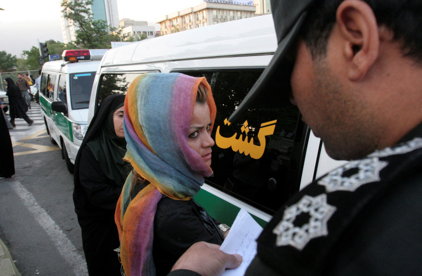 Morality police take down the name of a detained woman during a crackdown on ''social corruption'' in north Tehran, June 18, 2008. (credit: REUTERS/STRINGER/FILE PHOTO)