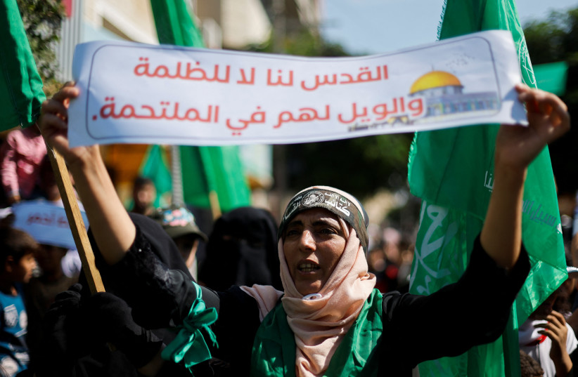  Palestinian Hamas supporters take part in an anti-Israel rally over tensions in Jerusalem's Al-Aqsa Mosque, in Khan Younis in the southern Gaza Strip on October 14, 2022 (photo credit: REUTERS/IBRAHEEM ABU MUSTAFA)