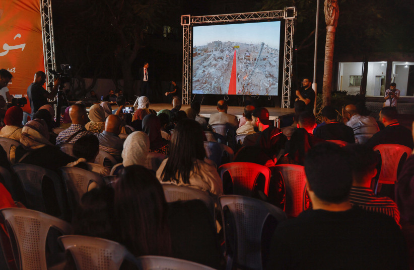  Palestinians watch the sixth edition of the Red Carpet Film Festival, at a newly innovated theatre in Gaza City, October 13, 2022.  (photo credit: REUTERS/IBRAHEEM ABU MUSTAFA)