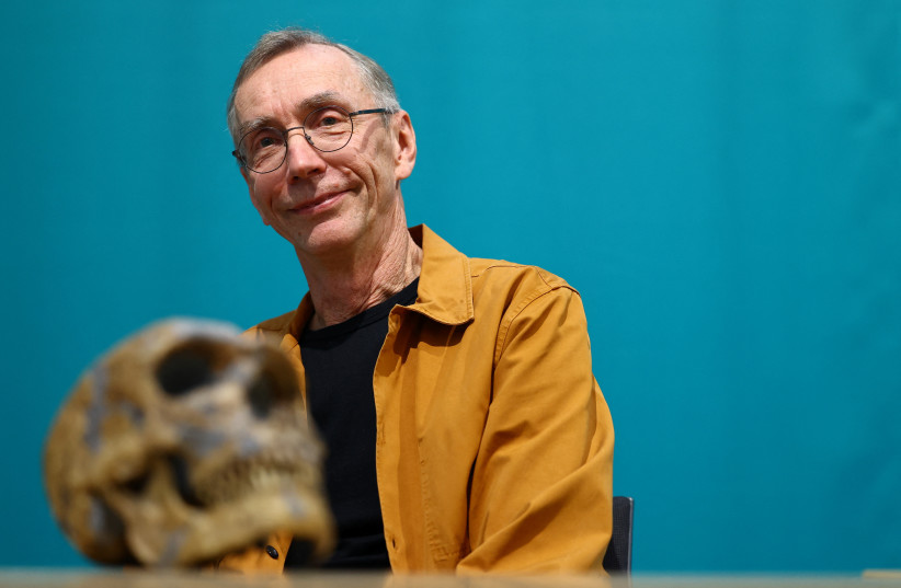 Geneticist Svante Paabo, who won the 2022 Nobel Prize in Physiology or Medicine for discoveries that underpin our understanding of how modern day humans evolved from extinct ancestors, poses with a Neanderthal skull at the Max-Planck Institute for evolutionary anthropology in Leipzig, Germany. (credit: REUTERS/LISI NIESNER)