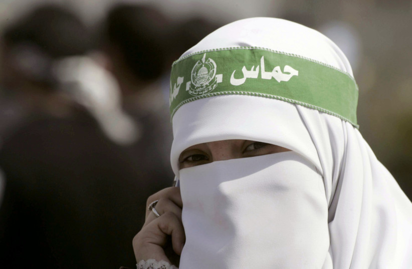  A veiled Palestinian Hamas supporter talks on her mobile phone during student council elections at Palestine Polytechnic University in the West Bank city of Hebron March 19, 2007 (credit: NAYEF HASHLAMOUN/REUTERS)