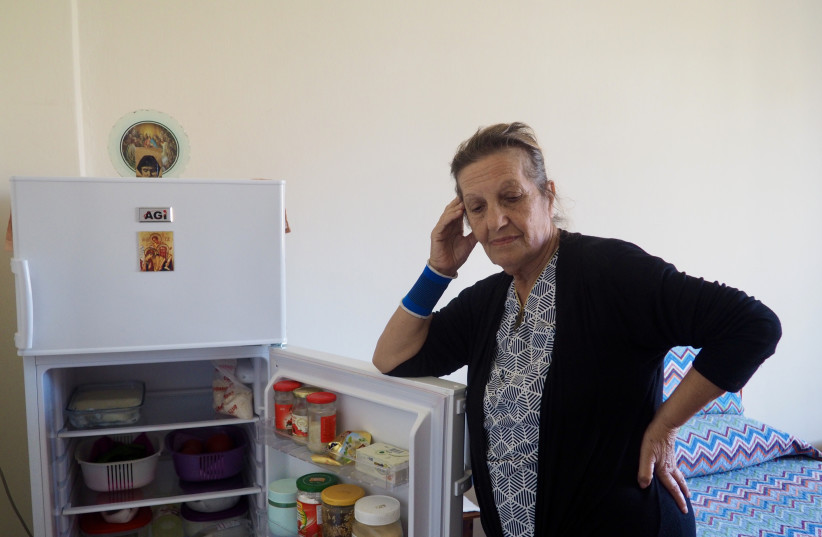 Beirut resident Em Rafi, 77, displays the contents of her refrigerator, which are in danger oif spoiling during the many hours when she does not have electricity. (credit: THE MEDIA LINE)