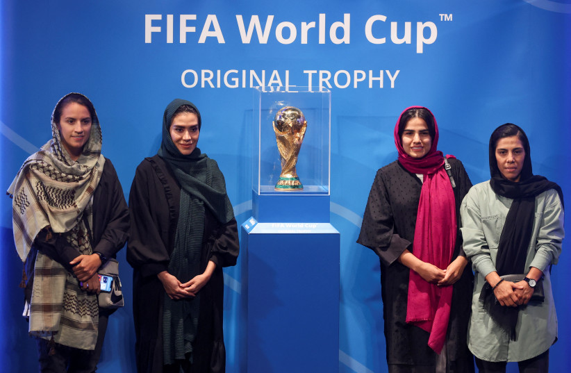  Iranian women football players stand next to the FIFA World Cup Trophy during an unveiling ceremony in Tehran, Iran September 1, 2022 (credit: MAJID ASGARIPOUR/WANA (WEST ASIA NEWS AGENCY) VIA REUTERS)