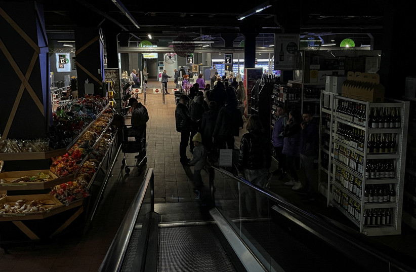 People visit in a supermarket without electricity, after a Russian missile attack, as Russia's invasion of Ukraine continues, in Kyiv, Ukraine, October 22, 2022. (photo credit: REUTERS/GLEB GARANICH)