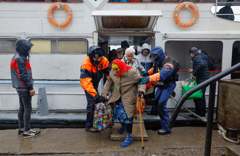  Civilians evacuated from the Russian-controlled city of Kherson walk from a ferry to board a bus heading to Crimea, in the town of Oleshky, Kherson region, Russian-controlled Ukraine October 23, 2022. (credit: REUTERS/ALEXANDER ERMOCHENKO)