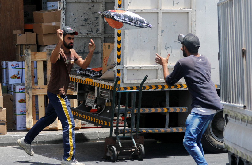  Asian workers unload a truck during afternoon hours at the central market, in Manama (credit: REUTERS)