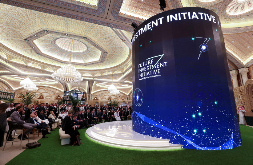  Participants watch the opening ceremony of the Future Investment Initiative (FII) conference on a digital screen in the lobby of the Exhibition and Conference Center at the Ritz Carlton Hotel, in Riyadh, Saudi Arabia, October 25, 2022. (photo credit: REUTERS/AHMED YOSRI)