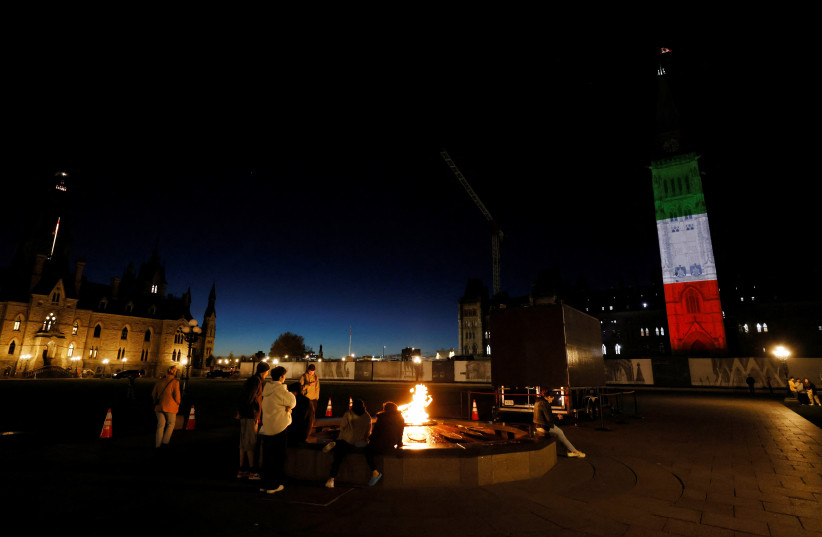 The Peace Tower on Parliament Hill in Ottawa, Canada, is illuminated in the colours of the Iranian flag in a show of solidarity for protests that have erupted following the death of Mahsa Amini, October 3, 2022. (credit: REUTERS/BLAIR GABLE)
