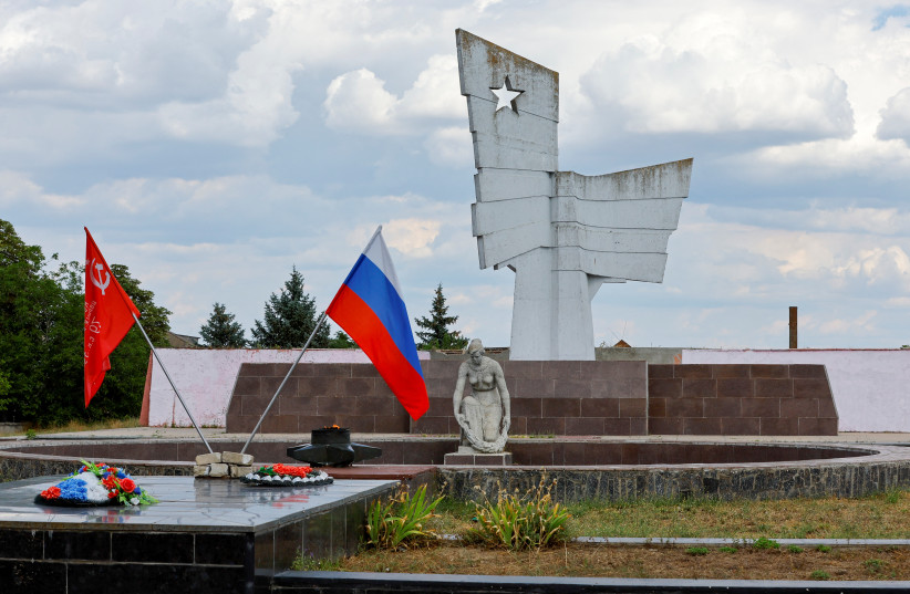  A view shows a Russian and Soviet-era flags at a World War Two memorial during Ukraine-Russia conflict in the Russia-controlled village of Chornobaivka, Ukraine July 26, 2022.  (credit: REUTERS/ALEXANDER ERMOCHENKO)