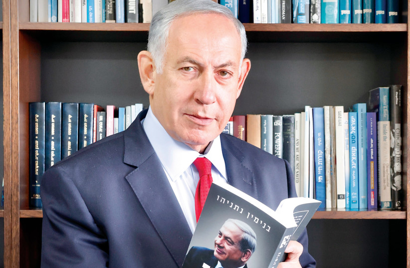  Benjamin Netanyahu (Likud) holds up his new autobiography, ‘Bibi: My Story.’ (credit: MARC ISRAEL SELLEM)