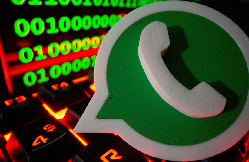  A 3D printed Whatsapp logo is pictured on a keyboard in front of binary code in this illustration taken September 24, 2021. (photo credit: REUTERS/DADO RUVIC/ILLUSTRATION)