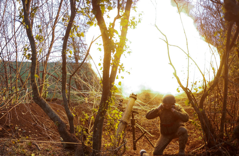 A Ukrainian serviceman fires with a mortar toward Russian positions, amid Russia's attack on Ukraine, in a frontline in Mykolaiv region, Ukraine, October 28, 2022. (photo credit: REUTERS/VALENTYN OGIRENKO)