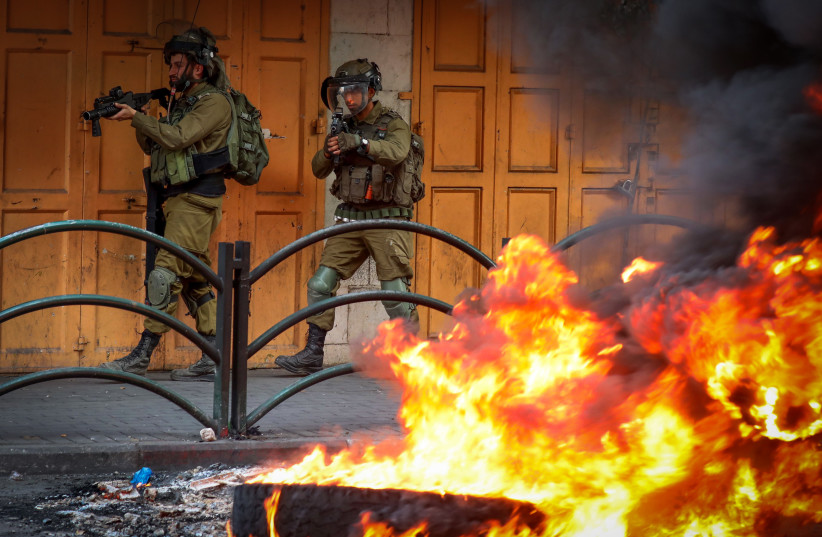  Palestinian youth clash with Israeli soldiers in the West Bank city of Hebron, October 28, 2022.  (credit: WISAM HASHLAMOUN/FLASH90)