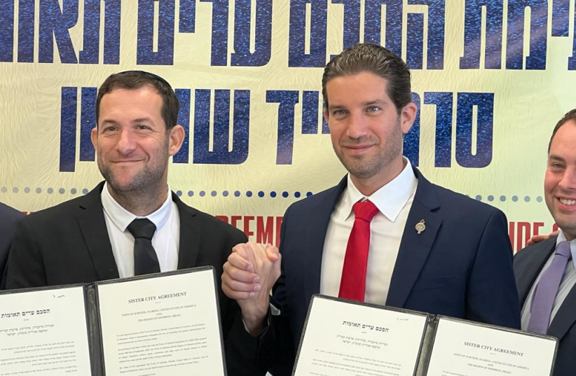  Samaria Regional Council head Yossi Dagan and the Mayor of Surfside Florida hold up the sister city agreements they signed together in the council's office on Thursday. (photo credit: TOVAH LAZAROFF)