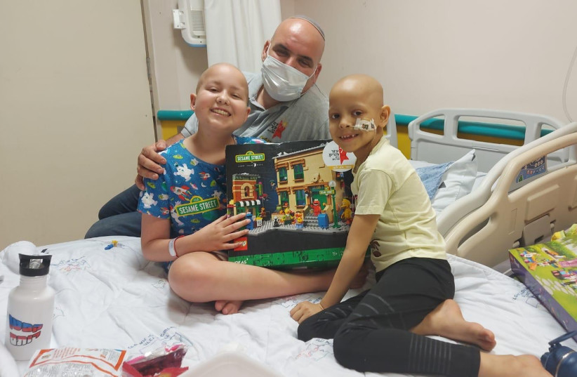  Maj.(res.) Maor Cohen delights hospitalized children with a new Lego set. (photo credit: COURTESY OF MAOR COHEN)
