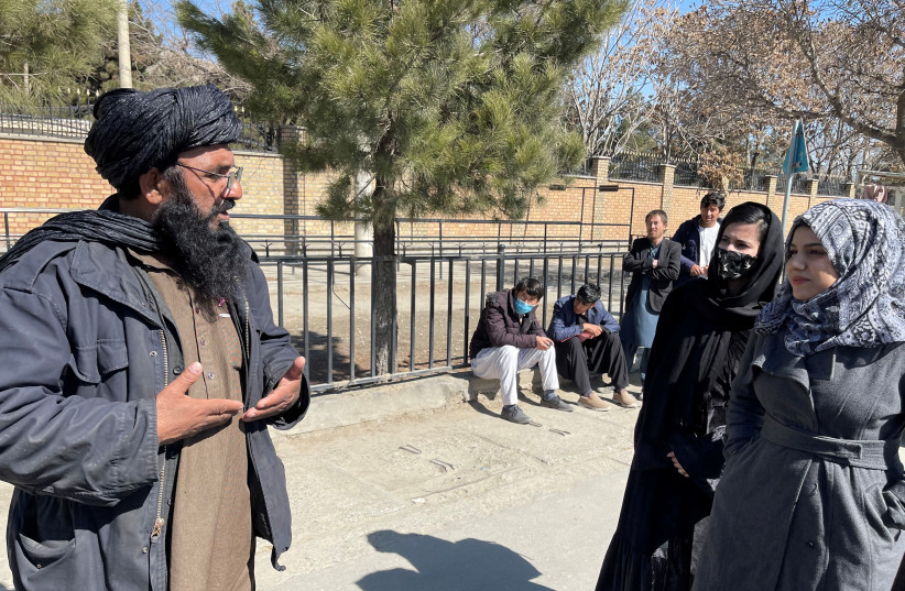  A member of Taliban speaks with female students outside the Kabul Education University in Kabul, Afghanistan, February 26, 2022. (credit: STRINGER/ REUTERS)
