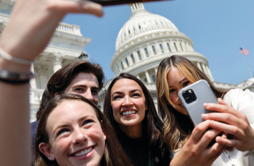  US REP. Alexandria Ocasio-Cortez, along with staff members and interns, takes a selfie at the Capitol in Washington. The writer asks: What happened to all those who had gathered around AOC, ready to anoint the queen of progressives as the savior? (photo credit: JONATHAN ERNST/REUTERS)