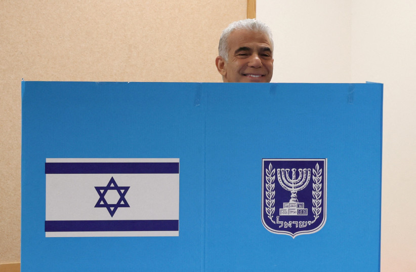  Israeli Prime Minister Yair Lapid smiles as he casts his vote at a polling station in Israel's coastal city of Tel Aviv in the country's fifth election in four years on November 1, 2022. (credit: Photo by JACK GUEZ/Pool via REUTERS)
