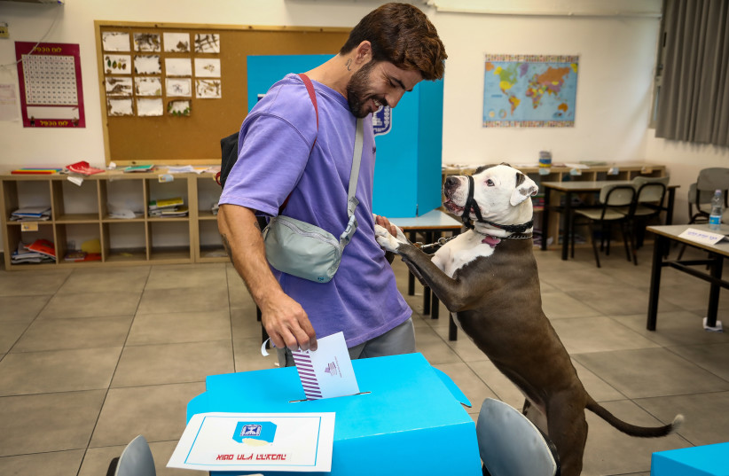  A man casts his vote with his dog at a voting station in Tel Aviv, during the Knesset Elections, on November 1, 2022. (photo credit: Gideon Markowicz/Flash90)