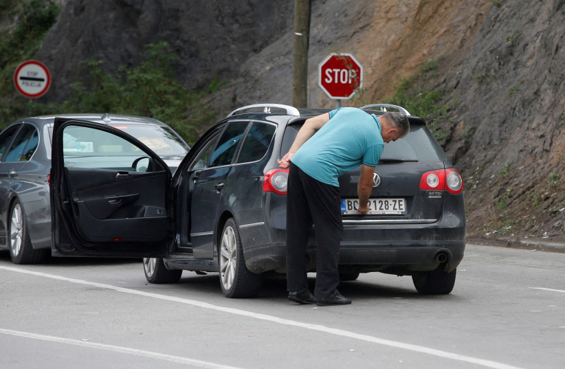  A driver removes a sticker covering the national markings on his car plates at the Jarinje border crossing, Kosovo September 1, 2022. (credit: OGNEN TEOFILOVSKI/REUTERS)
