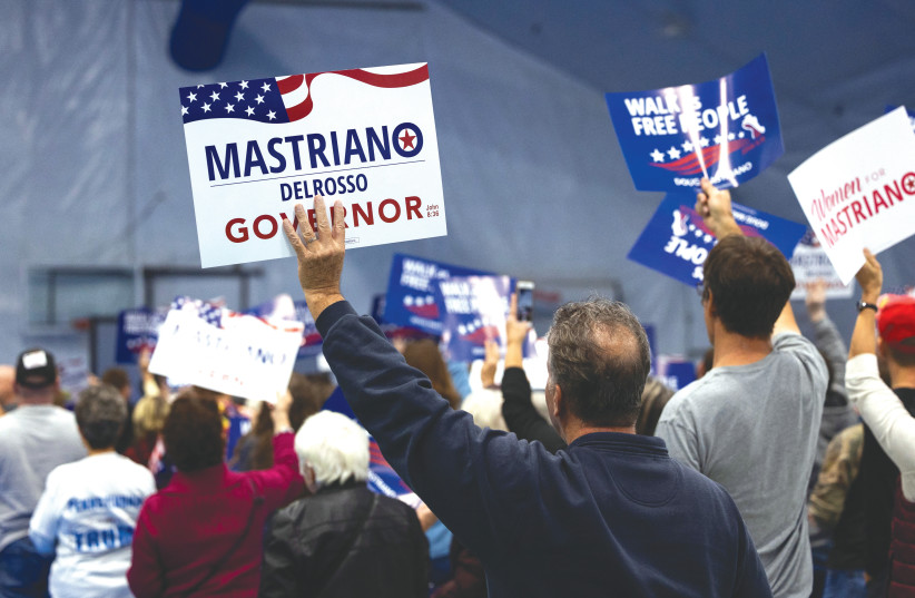  SUPPORTERS HOLD UP signs at a Republican Pennsylvania gubernatorial event with candidate Doug Mastriano, ahead of the midterm elections on Tuesday. (photo credit: RACHEL WISNIEWSKI/REUTERS)