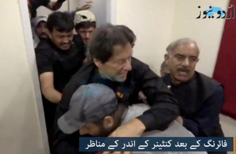  Former Pakistani Prime Minister Imran Khan is helped after he was shot in the shin in Wazirabad, Pakistan November 3, 2022 in this still image obtained from video. (photo credit: URDU MEDIA VIA REUTERS)