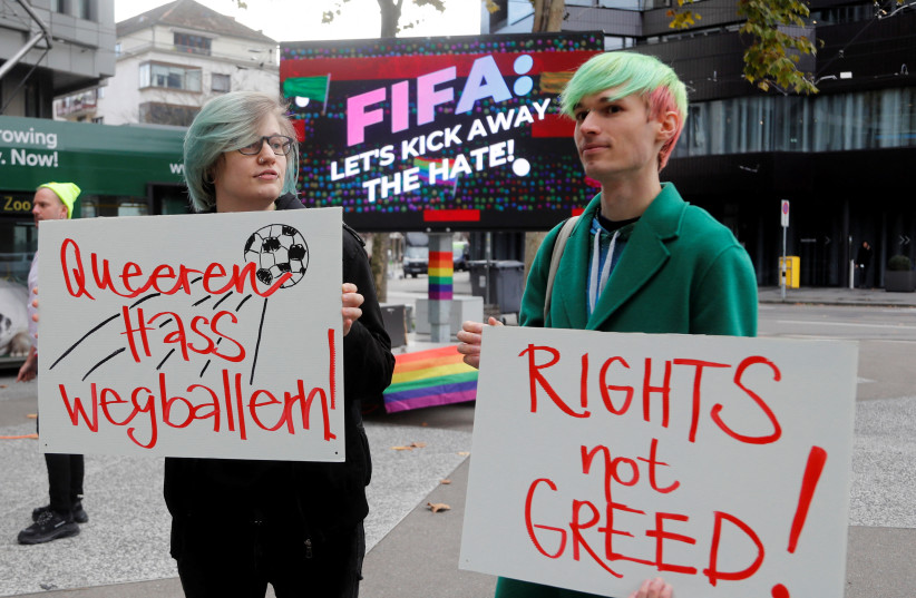  Participants display placards as LGBT+ associations protest in front of FIFA World Football Museum, as Qatar is set to host the 2022 World Cup, in Zurich, Switzerland November 8, 2022 (photo credit: REUTERS/ARND WIEGMANN)