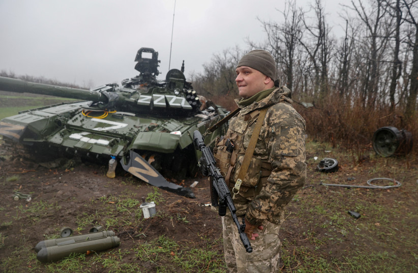  A Ukrainian service member stands next to a damaged Russian tank T-72 BV, as Russia's attack on Ukraine continues, in Donetsk region (credit: REUTERS)