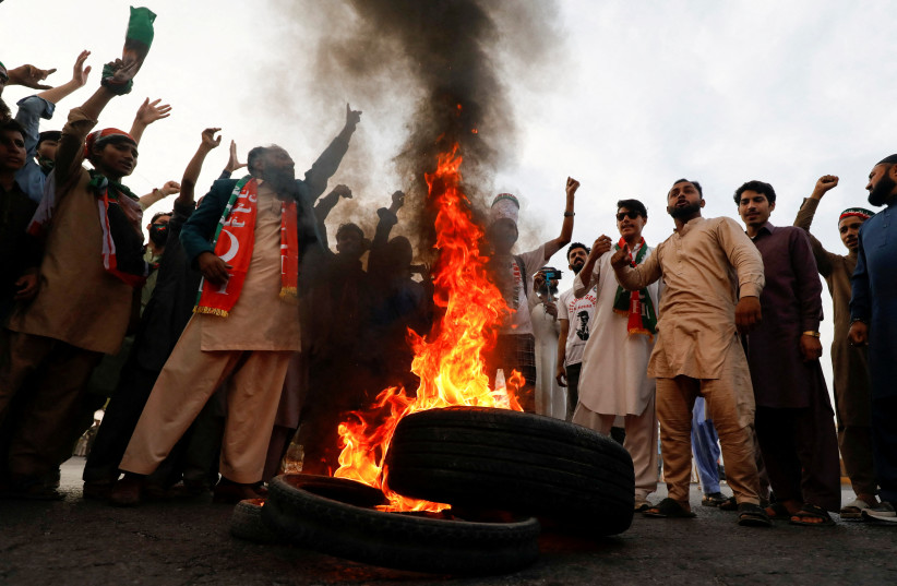  People chant slogans as they burn tires to block main highway during a protest to condemn the shooting incident on a long march held by Pakistan's former Prime Minister Imran Khan, in Wazirabad, Pakistan November 4, 2022. (credit: REUTERS/AKHTAR SOOMRO)