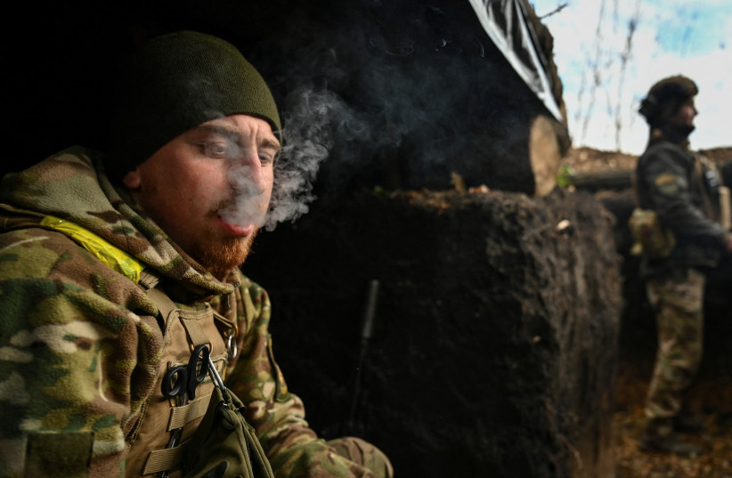  A serviceman smokes in a trench at his position on a front line, amid Russia's attack on Ukraine, in Zaporizhzhia region, Ukraine November 3, 2022.  (photo credit: STRINGER/ REUTERS)