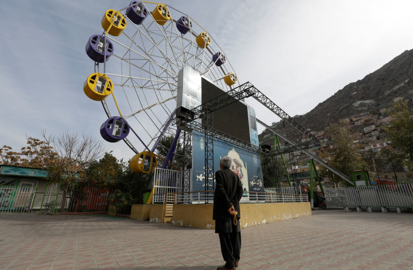  An Afghan man stands in an amusement park in Kabul, Afghanistan, November 9, 2022 (photo credit:  REUTERS/ALI KHARA)