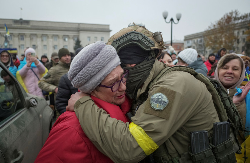  A local resident hugs Ukrainian serviceman as people celebrate after Russia's retreat from Kherson, in central Kherson, Ukraine November 12, 2022 (photo credit:  REUTERS/Lesko Kromplitz)