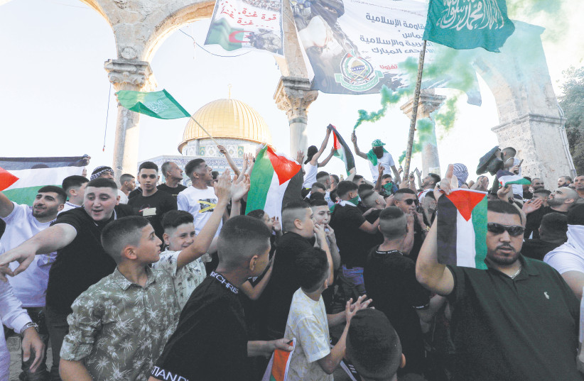  PALESTINIANS WAVE flags and banners at al-Aqsa Mosque, on the holiday of Eid al-Adha, in July.  (photo credit: JAMAL AWAD/FLASH90)