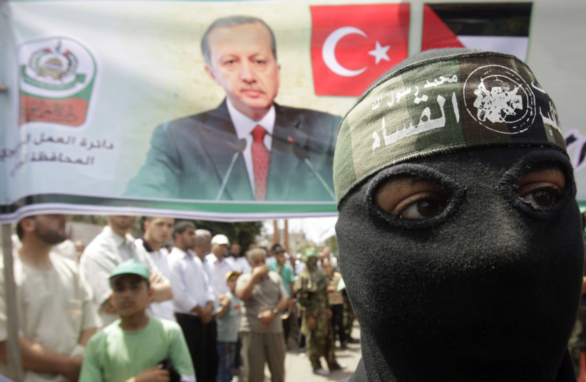  A masked member of Hamas stands in front of a banner depicting Turkey's Prime Minister Tayyip Erdogan during a protest in Central Gaza Strip June 4, 2010 (photo credit: REUTERS/IBRAHEEM ABU MUSTAFA)