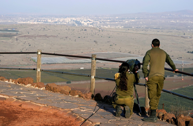  Israeli soldiers look towards Syria across the border from Mount Bental in Israel's Golan Heights, November 19, 2020 (photo credit: PATRICK SEMANSKY/POOL VIA REUTERS)
