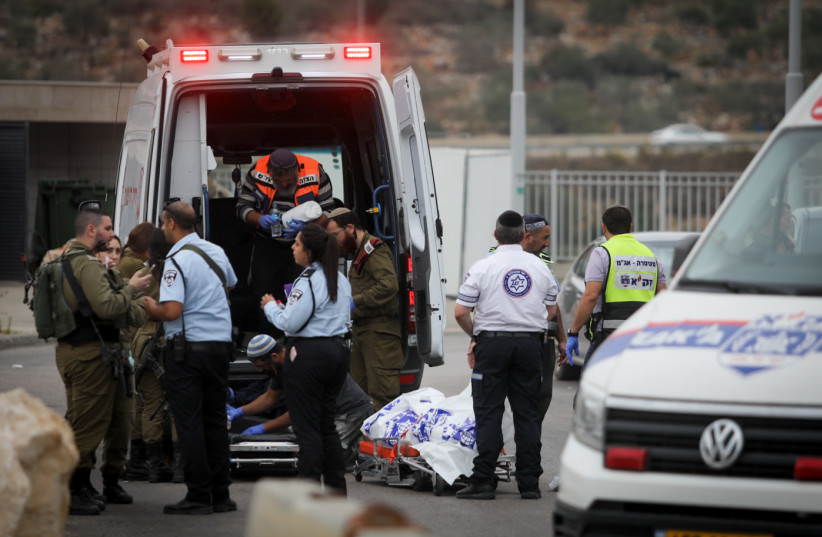 Medics remove the body of a man murdered in a stabbing attack earlier, outside Ariel, in the West Bank, on November 15, 2022. (photo credit: FLASH90)