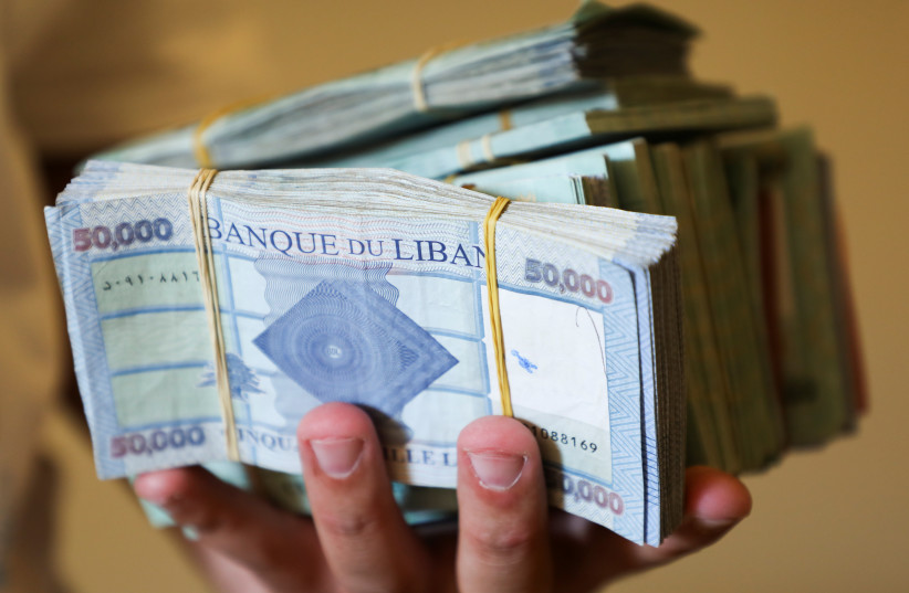  A money exchange vendor displays Lebanese pound banknotes at his shop in Beirut, Lebanon, June 11, 2021. (credit: MOHAMED AZAKIR/REUTERS)