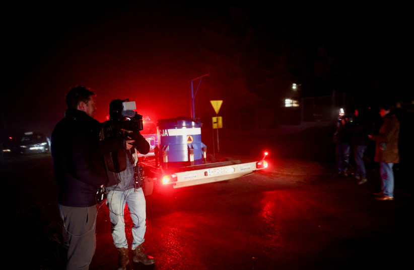  Members of the media stand near a police blockade as a police vehicle passes by after explosions in Przewodow, a village in eastern Poland near the border with Ukraine, November 16, 2022. (photo credit: KACPER PEMPEL/REUTERS)