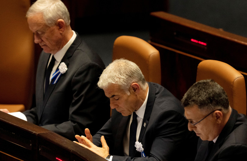  Outgoing Prime Minister Yair Lapid sits with National Unity Party leader Defense Minister Benny Gantz at the swearing-in ceremony for the new 25th Knesset, November 15, 2022. (credit: RONEN ZVULUN/REUTERS)