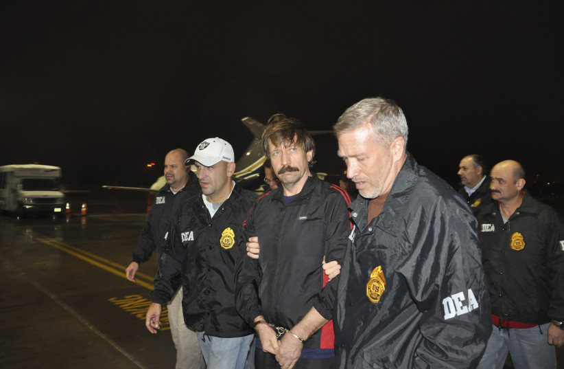  Russian arms dealer Viktor Bout (center) is escorted by Drug Enforcement Administration officers after arriving at Westchester County Airport in White Plains, New York, November 16, 2010.  (credit: REUTERS/US DEPARTMENT OF JUSTICE/HANDOUT)
