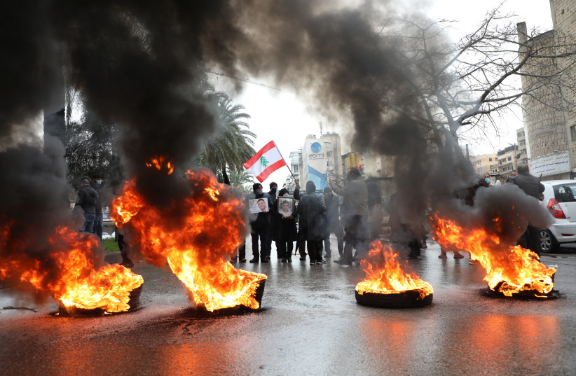  Relatives of victims of Beirut port explosion burn tires during a protest, after a Lebanese court removed the judge leading the investigation into the explosion, outside the Justice Palace in Beirut, Lebanon February 19, 2021 (credit: MOHAMED AZAKIR/REUTERS)