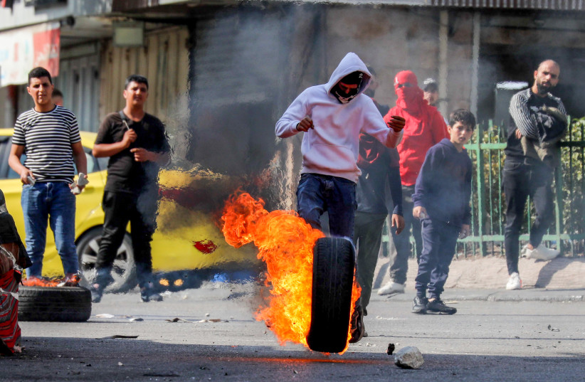  Palestinian youth clash with Israeli soldiers in the West Bank city of Hebron, October 30, 2022 (credit: WISAM HASHLAMOUN/FLASH90)
