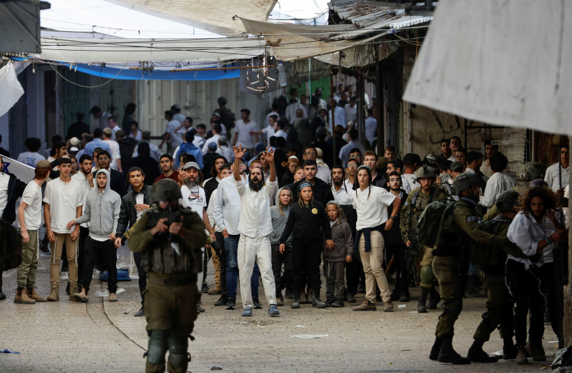  Israeli settlers gather during a scuffle with Palestinians in the West Bank city of Hebron, November 19, 2022. (credit: REUTERS/MUSSA QAWASMA)