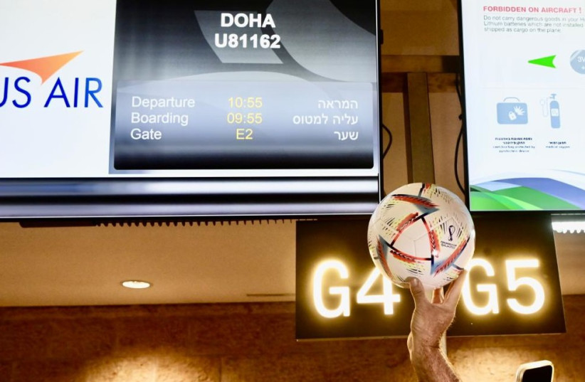  An excited traveler holds a soccer ball next to sign for flight leaving from TLV to DOH. (photo credit: MAARIV)